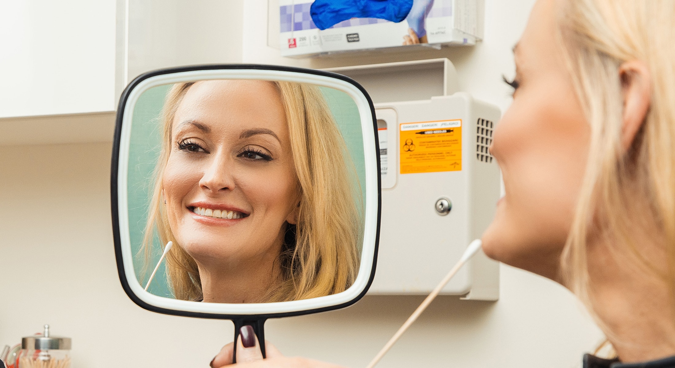 Woman smiling while looking in a mirror.