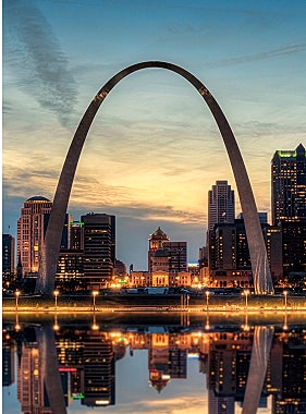 St. Louis Arch at sunset with city reflection.