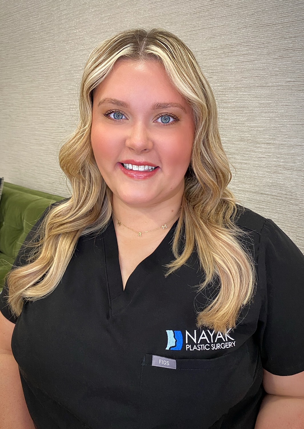 Woman in scrubs at plastic surgery clinic.