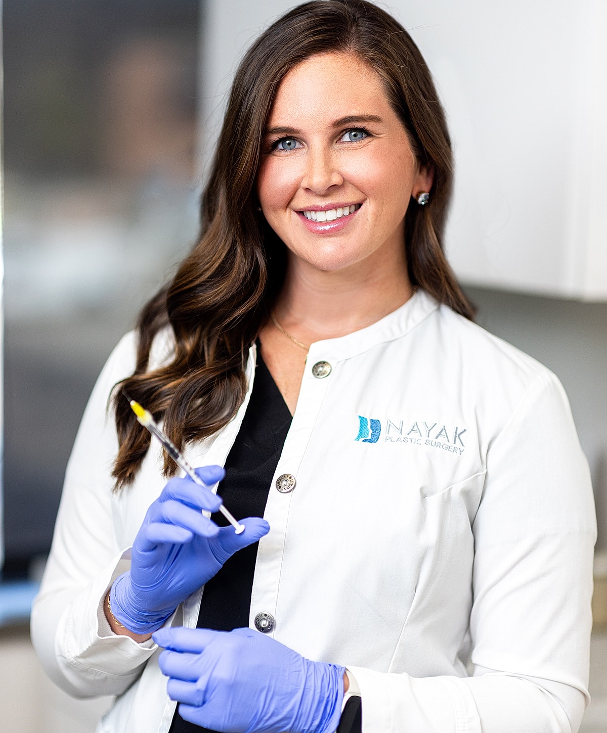 Smiling professional holding syringe in clinic.