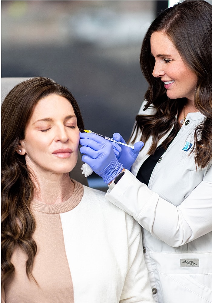 Patient receiving cosmetic treatment from a practitioner.