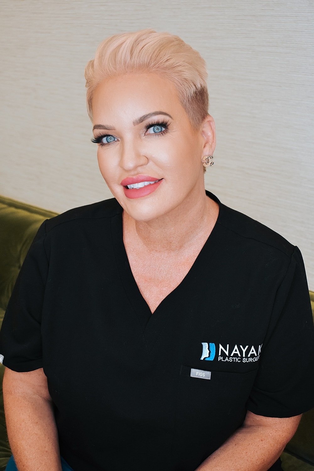 Woman in scrubs smiling at the camera.