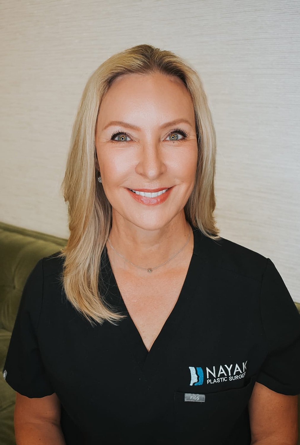 Smiling woman in black medical scrubs.