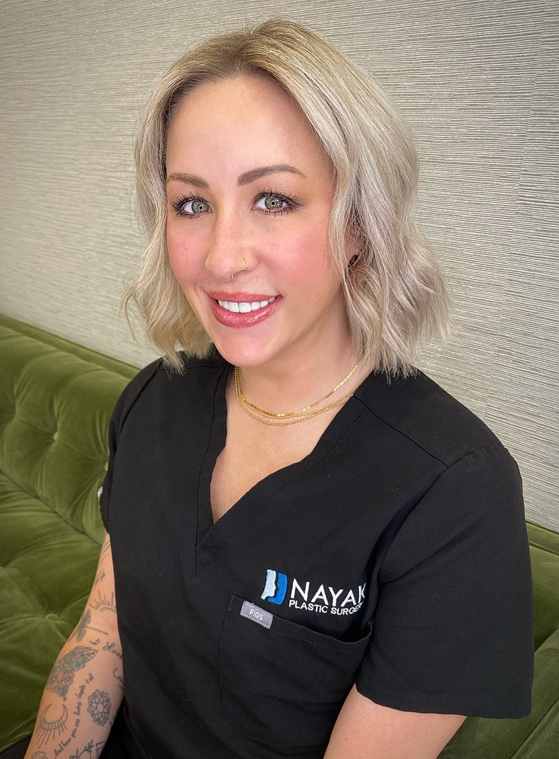 Smiling professional in medical attire, waiting.