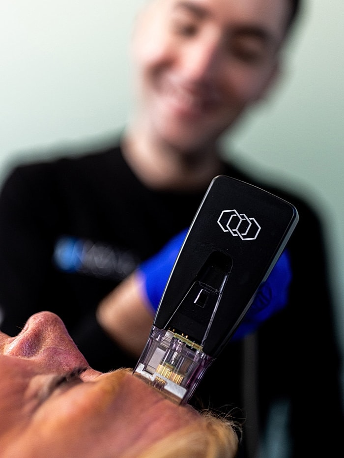Smiling woman touching her hair in black outfit.