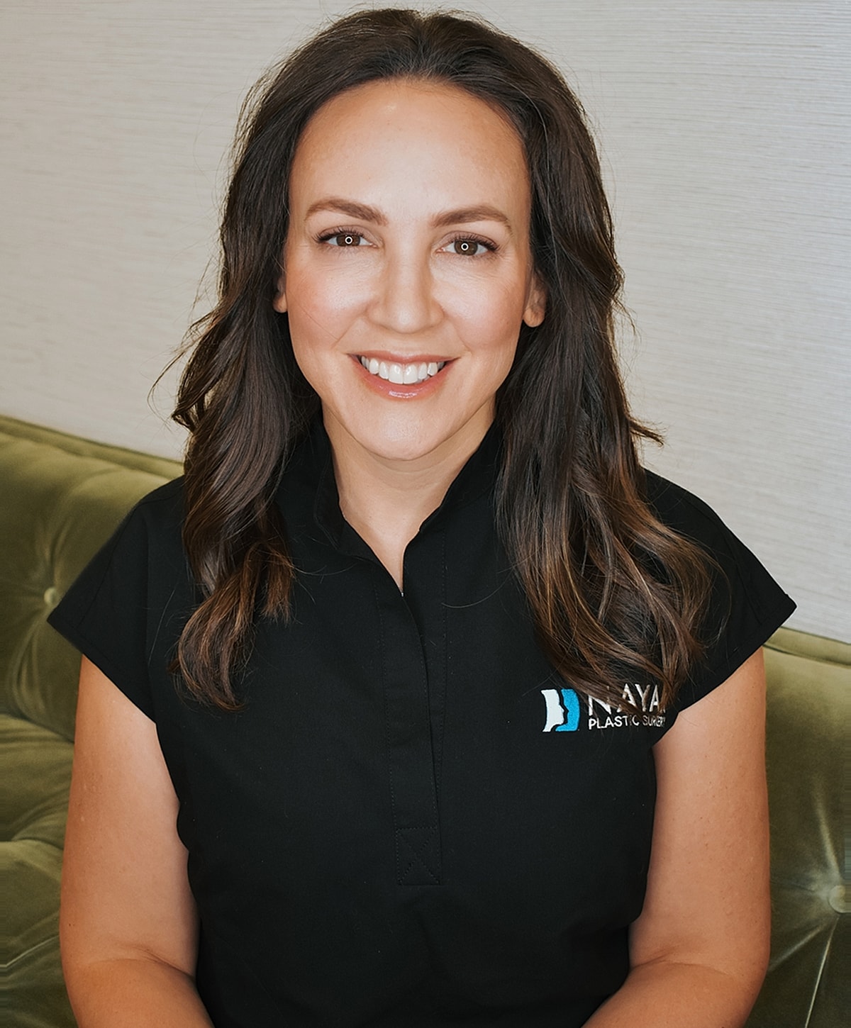 Smiling woman in professional medical attire.