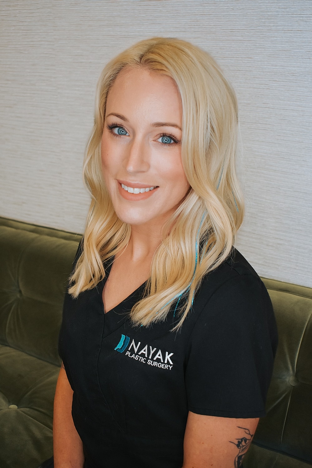 Smiling woman in medical attire at Nayak clinic.