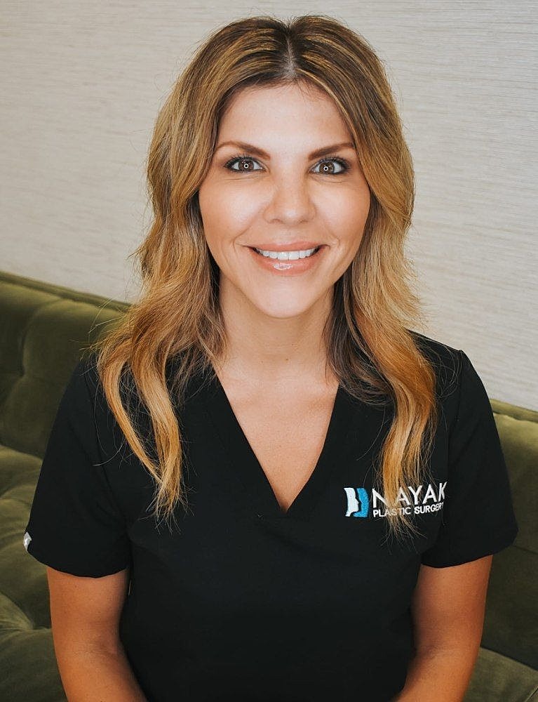 Woman smiling in medical uniform, indoors.