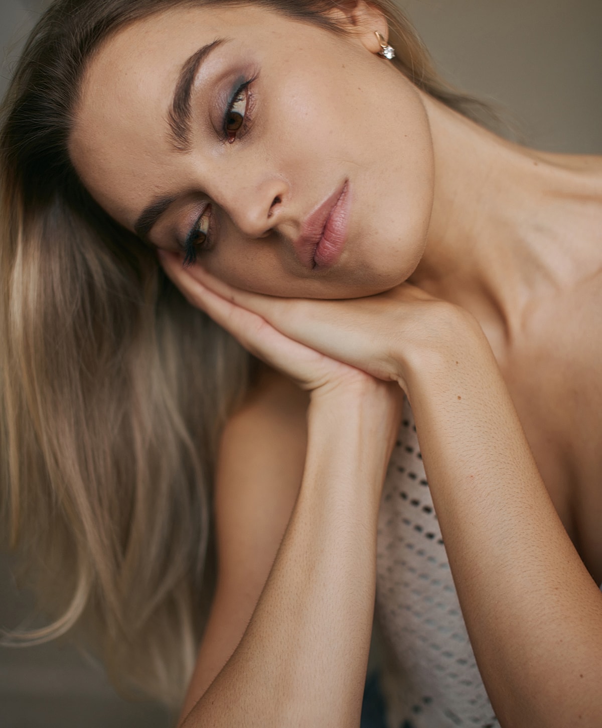 Woman resting her chin on her hands thoughtfully.