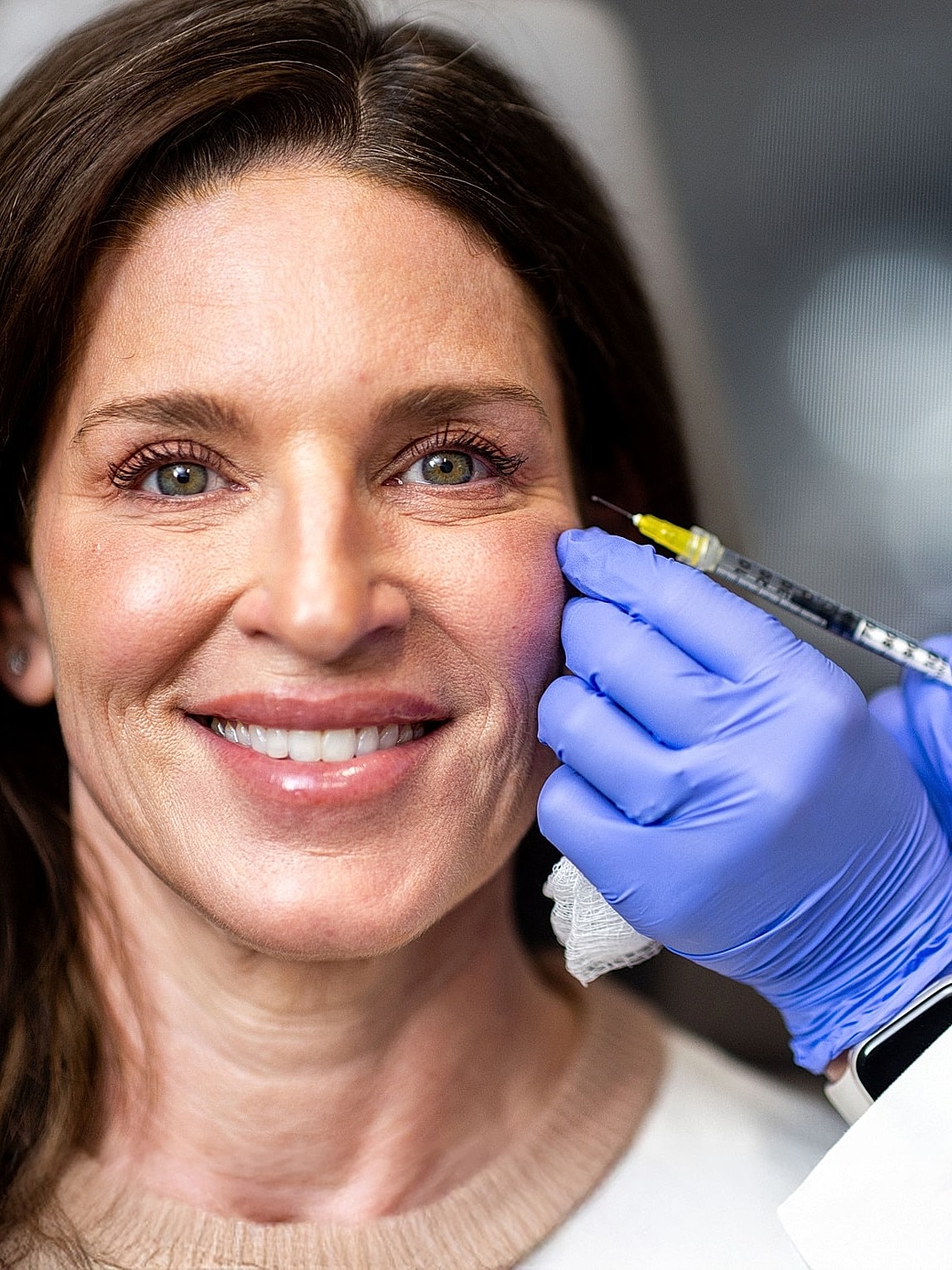 Patient receiving cosmetic injection in clinic setting.