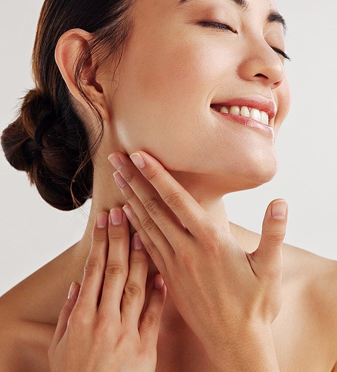 Woman joyfully touching her neck and face.
